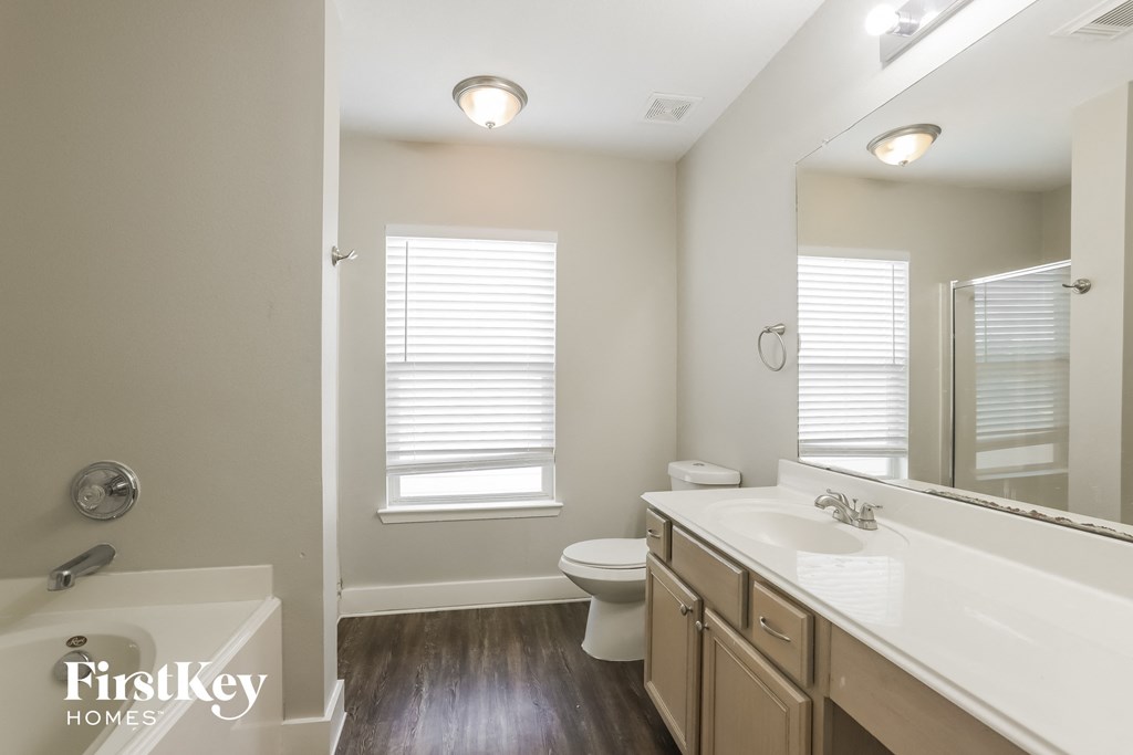 a bathroom with a large mirror and a sink and a toilet