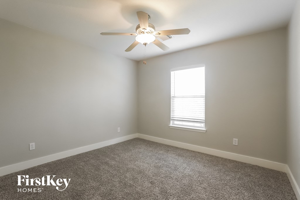 a bedroom with a ceiling fan and a window
