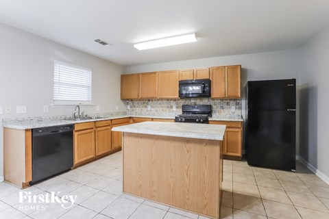 A kitchen with wooden cabinets and black appliances.