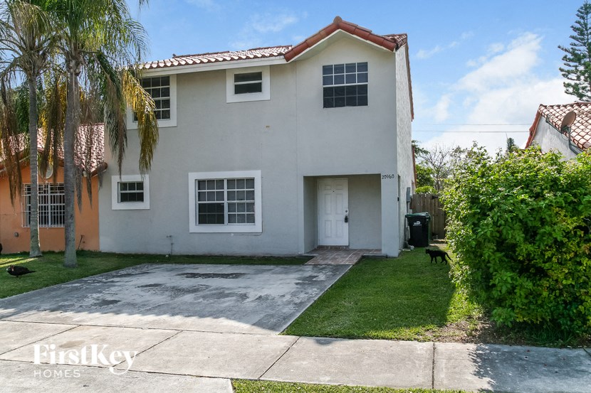 a white house with a yard and a driveway