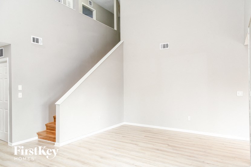 a white room with wooden floors and a staircase