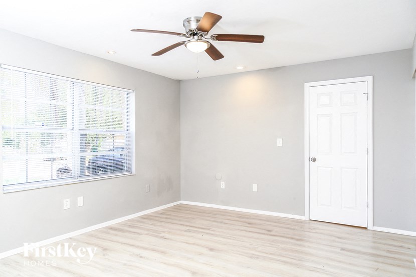 a living room with a ceiling fan and a window