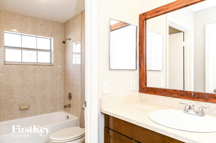 a bathroom with a sink toilet and a mirror