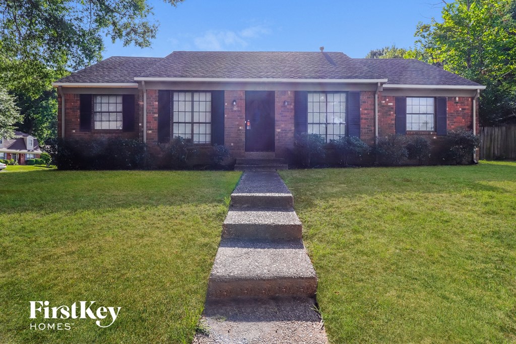 a home with a lawn and walkway in front of it