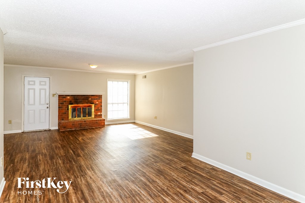 the living room with hardwood floors and a fireplace