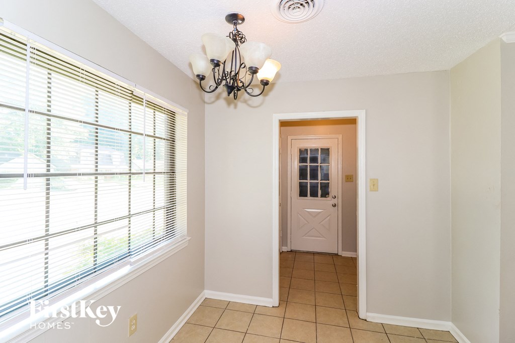 the entryway of a home with a large window and a white door