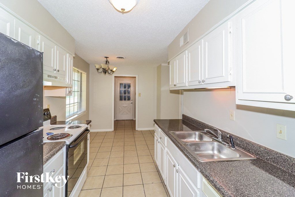a kitchen with white cabinets and granite counter tops
