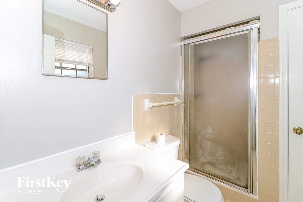 a bathroom with a shower and a sink and a toilet