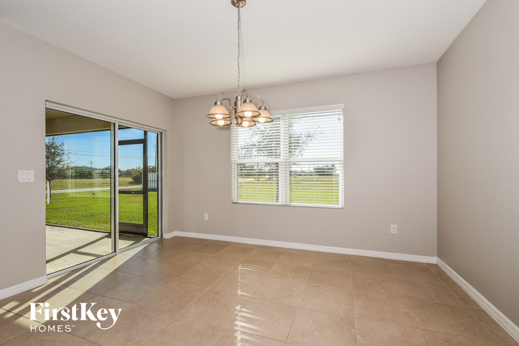 an empty living room with a sliding glass door to the backyard