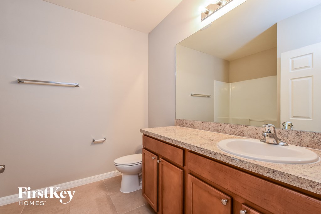 a full bathroom with a sink toilet and mirror