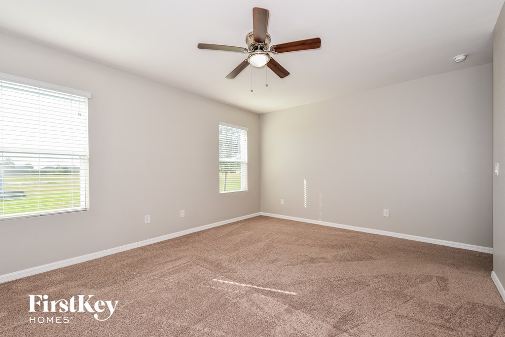 a living room with carpet and a ceiling fan