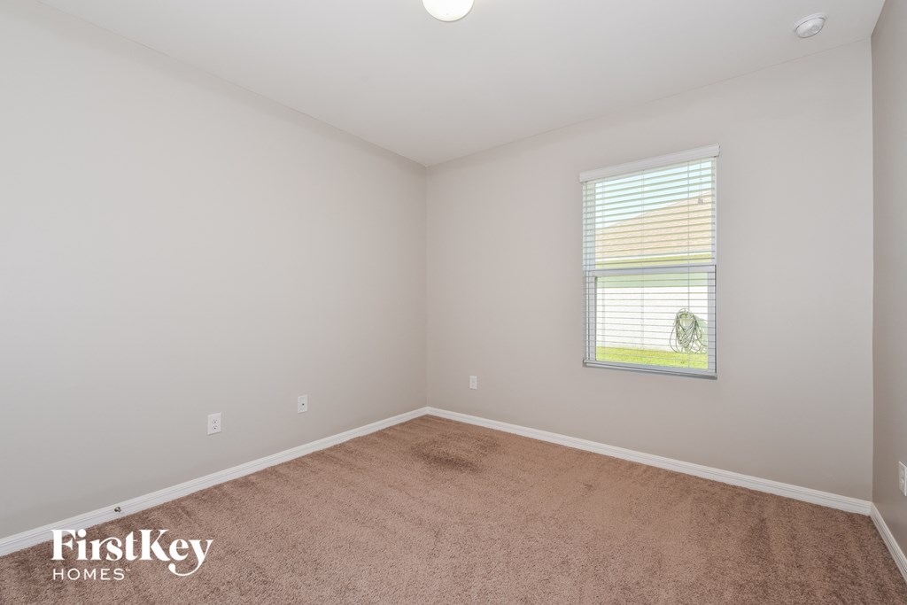 a bedroom with a carpeted floor and a window