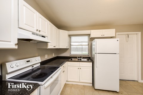 a white kitchen with white appliances and white cabinets