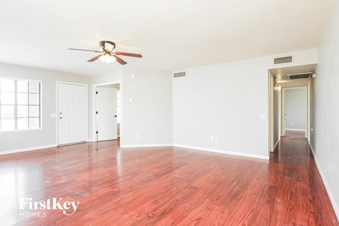 A room with a wooden floor and a ceiling fan.