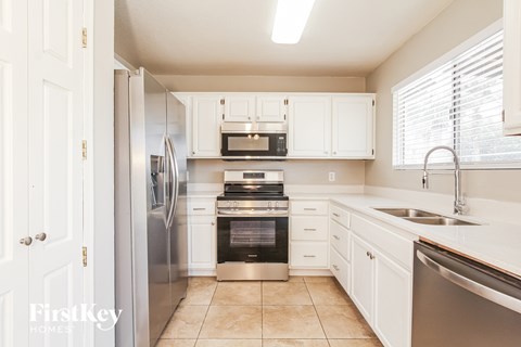 A kitchen with white cabinets and stainless steel appliances.