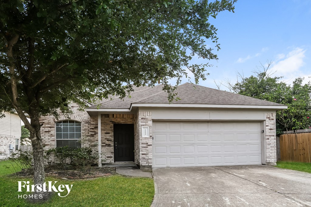 the front of a brick house with a white garage door