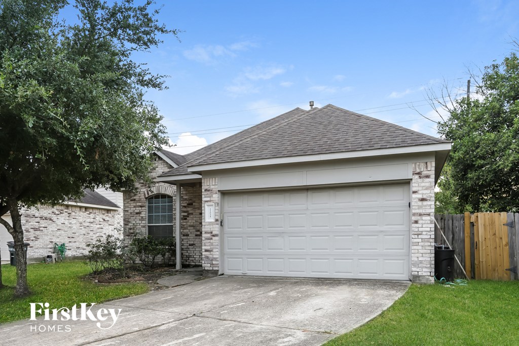 the front of a brick house with a white garage door