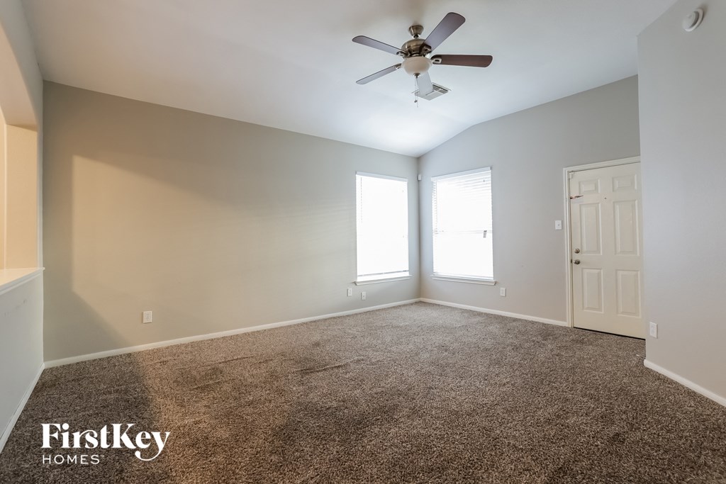 an empty room with a ceiling fan and a window