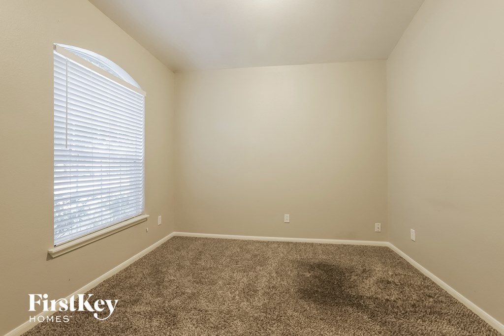 an empty room with carpet and a large window