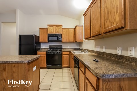 a kitchen with wooden cabinets and black appliances and granite counter tops