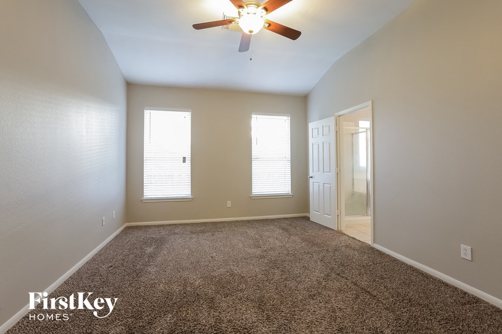 the master bedroom has a carpeted floor and a ceiling fan