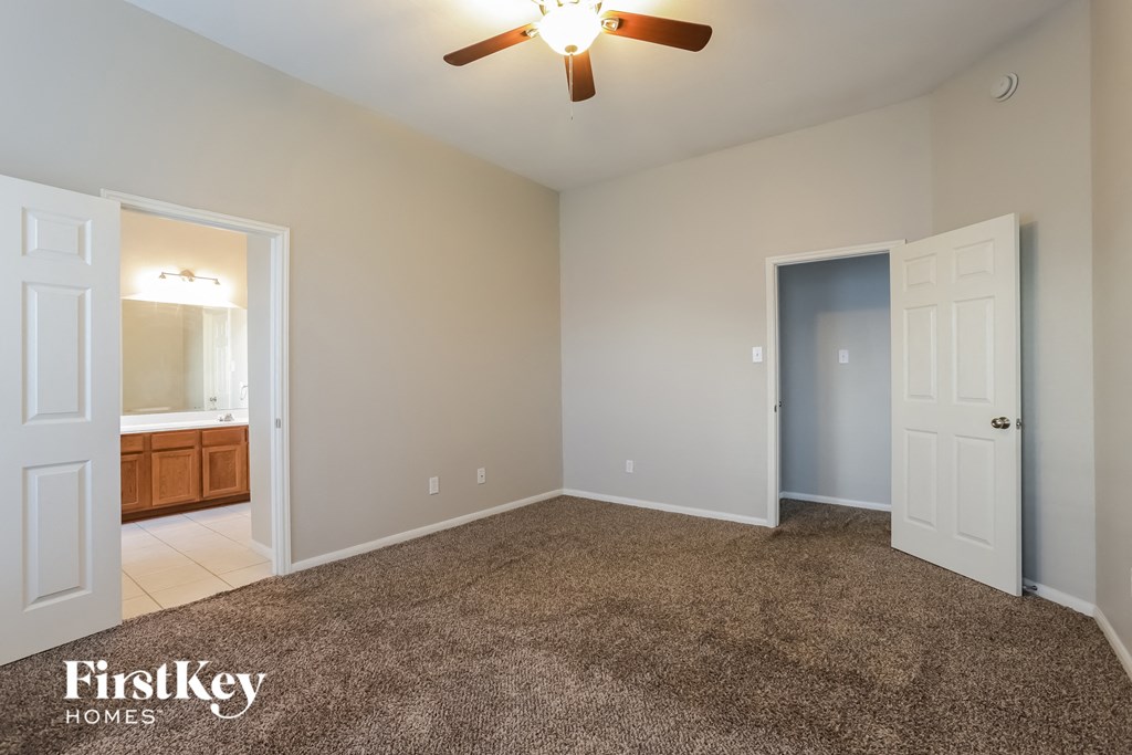 a bedroom with a carpeted floor and a door to a bathroom