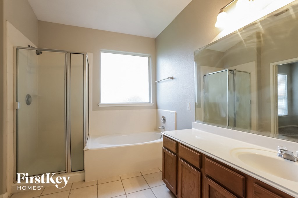 a bathroom with a sink and a shower and a tub