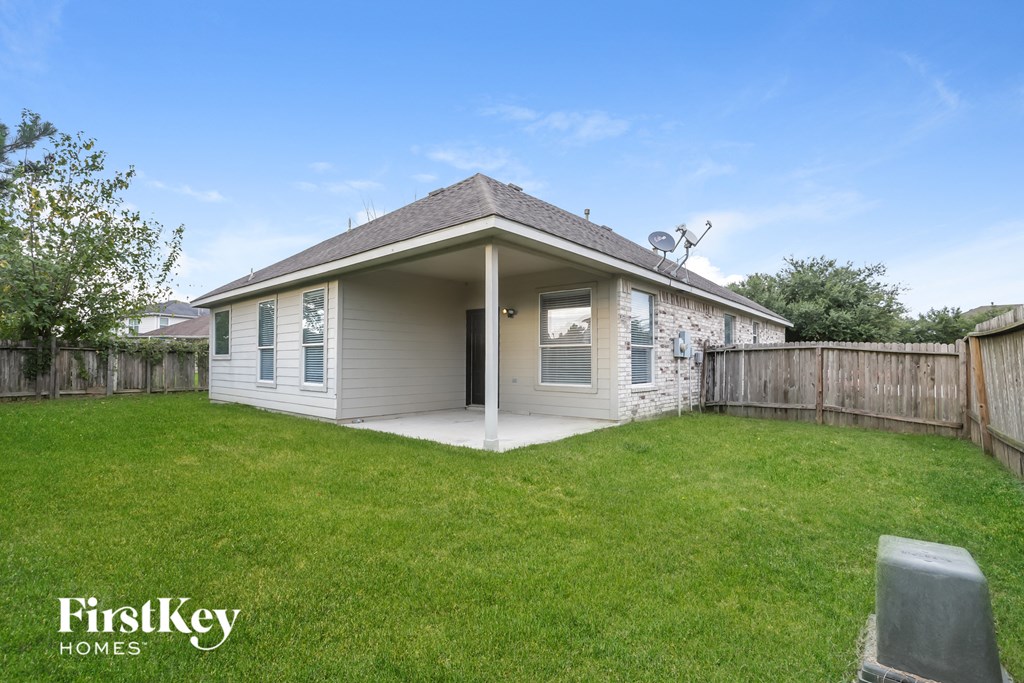 the backyard of a house with a lawn and a fence