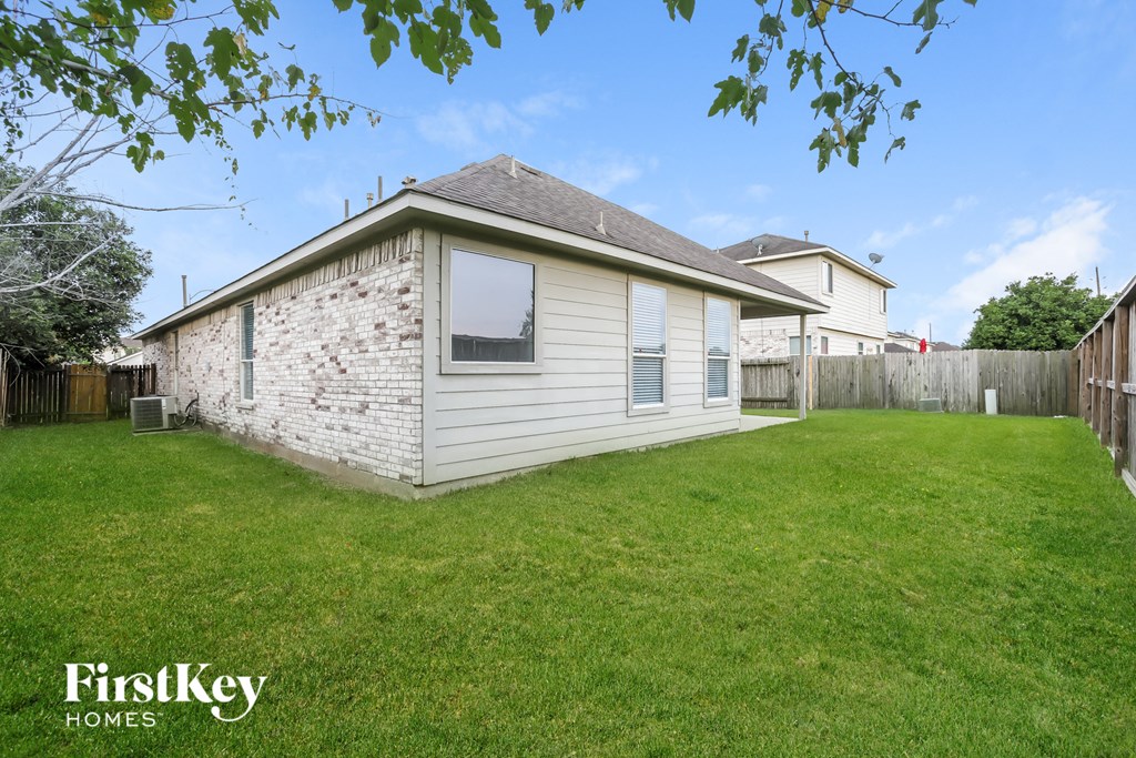 the backyard of a house with a yard and a fence