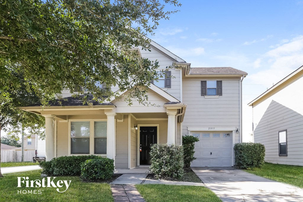 a white house with a tree in front of it