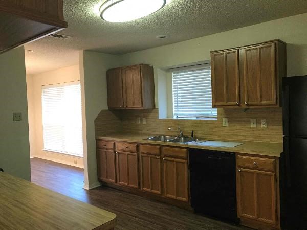 an empty kitchen with wooden cabinets and a sink