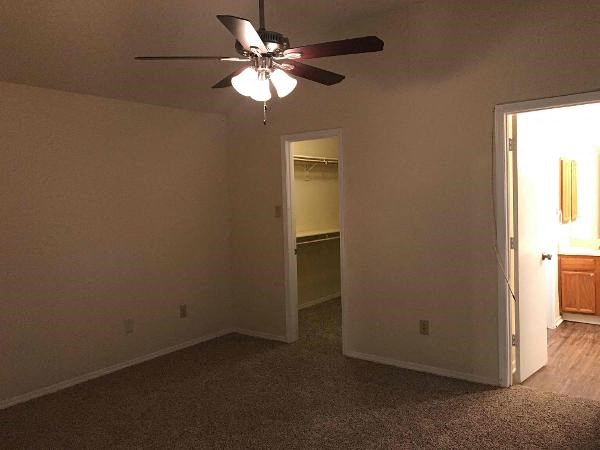 an empty living room with a ceiling fan