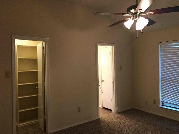 a living room with a ceiling fan and a closet