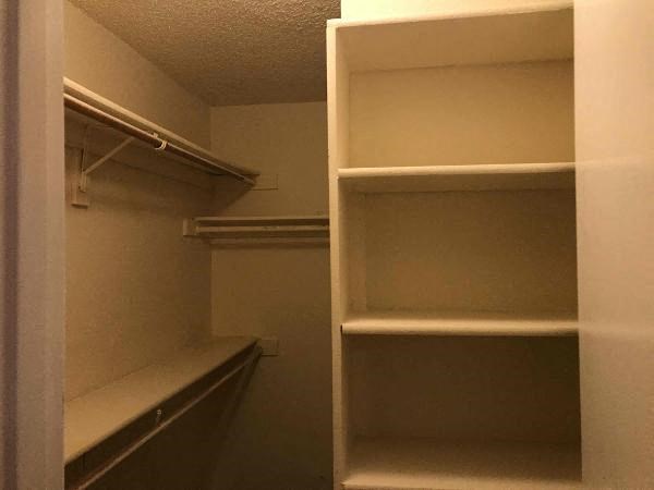 a walk in closet with empty shelves in it