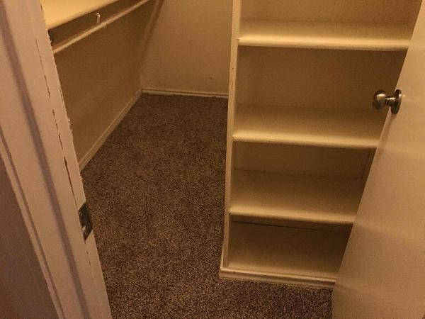 a closet with three shelves and a door