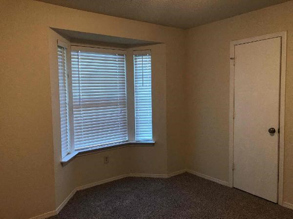 an empty room with a window and a door