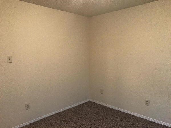 an empty room with white walls and a carpet