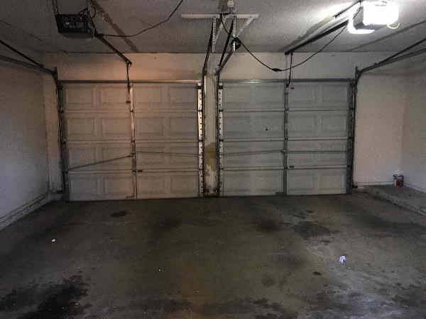 the inside of a garage with two white doors