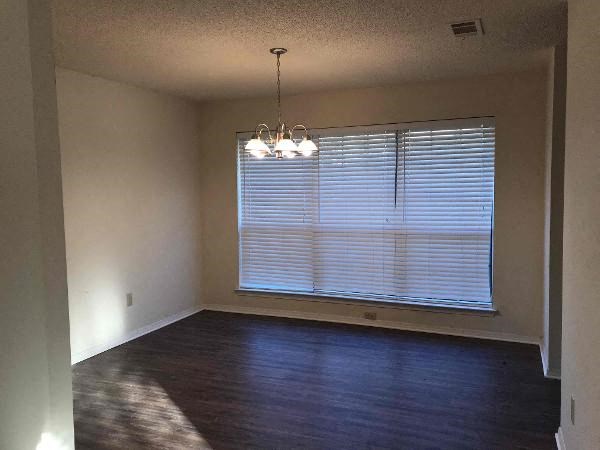 an empty living room with a large window and