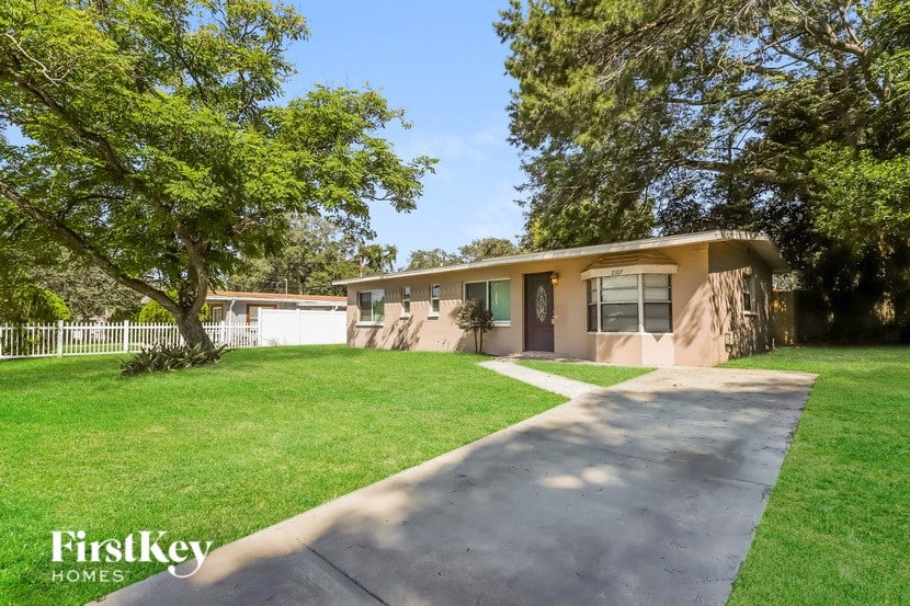a small brown house with a sidewalk and lawn