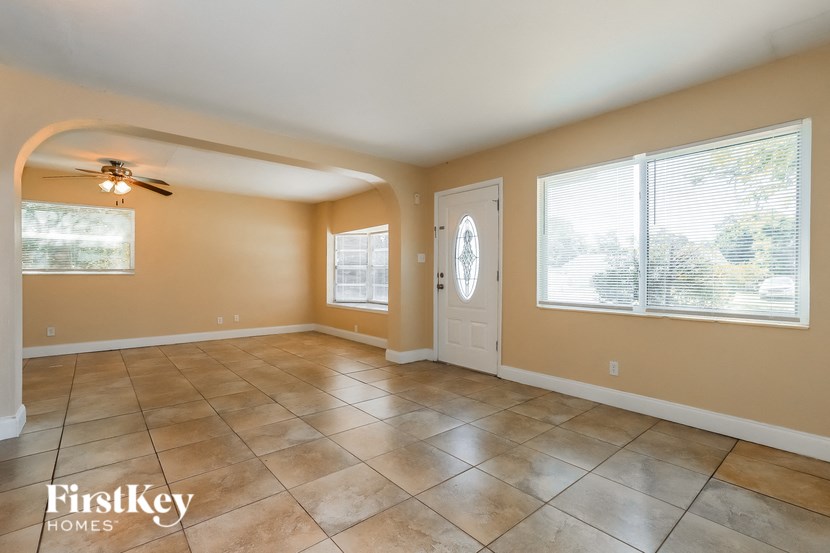 a large living room with tile flooring and a white door