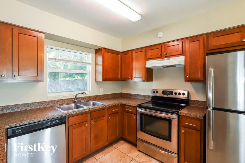 a kitchen with wooden cabinets and stainless steel appliances