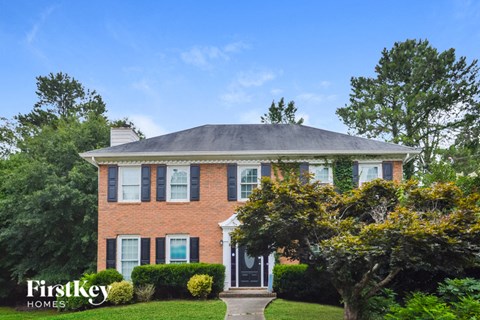 a brick house with a gray roof and a black door