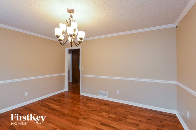 a living room with a hard wood floor and a chandelier