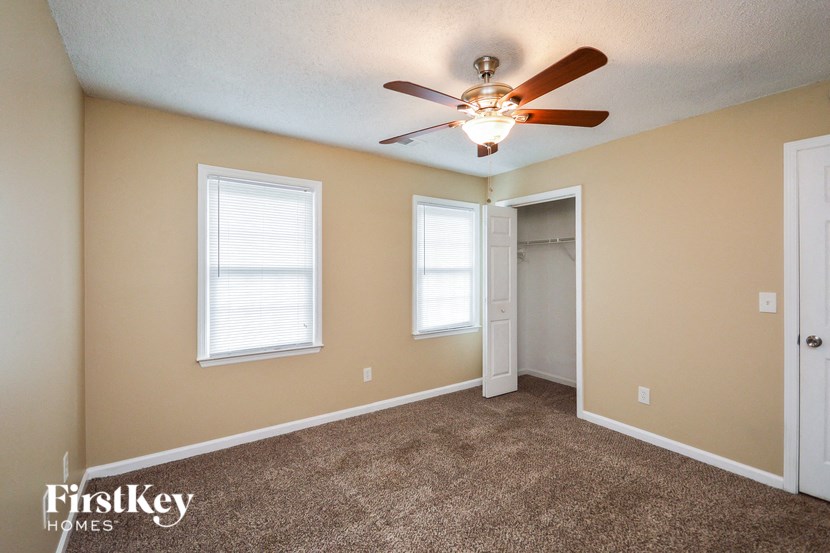 the living room of an empty house with a ceiling fan