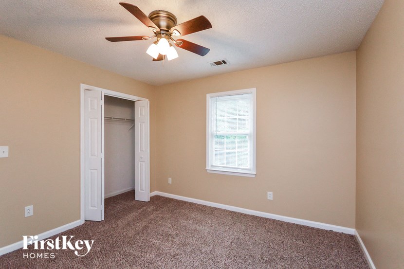 a bedroom with a ceiling fan and a closet