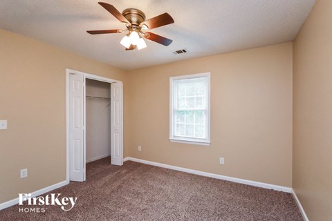 a bedroom with a ceiling fan and a closet