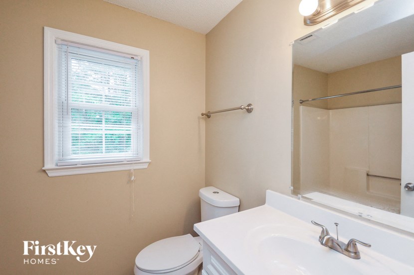 a bathroom with a sink toilet and a mirror