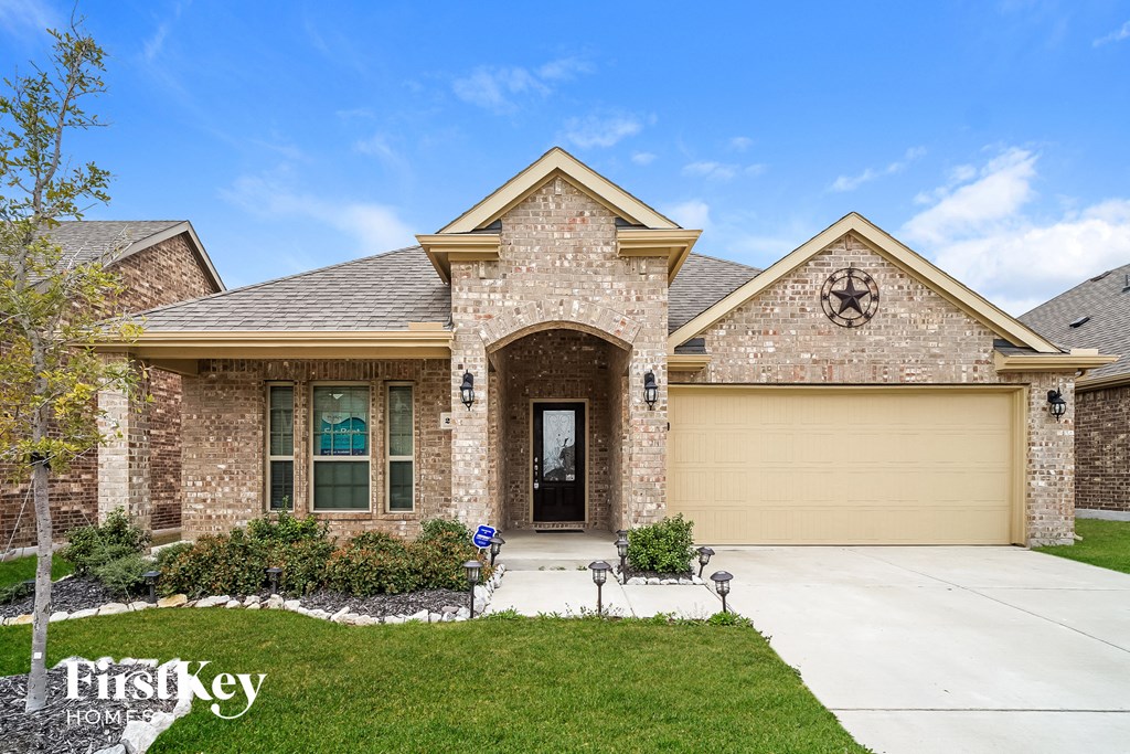 A house with a brick facade and a large front yard.
