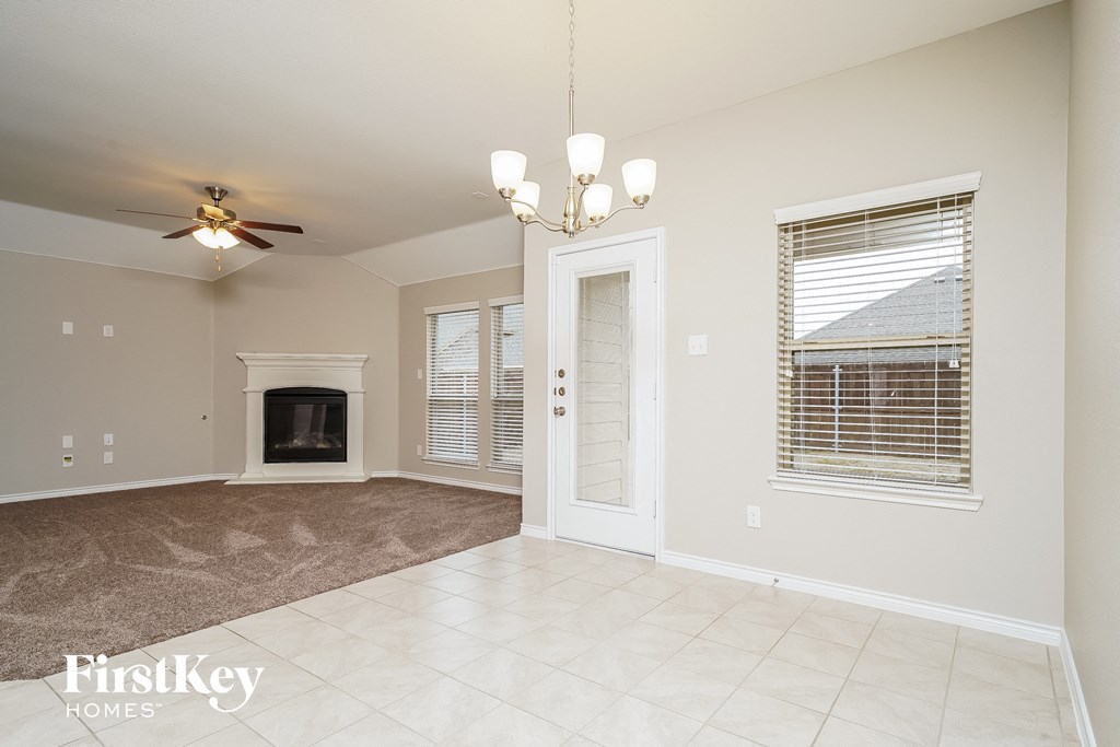 A spacious living room with a fireplace and a ceiling fan.
